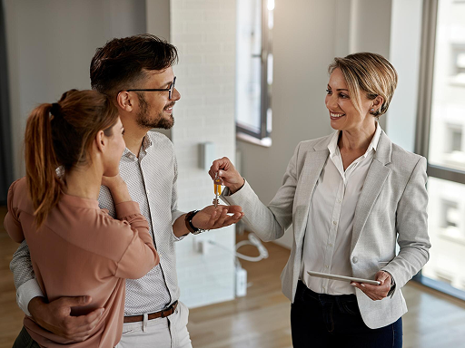 Real estate broker giving property keys to couple